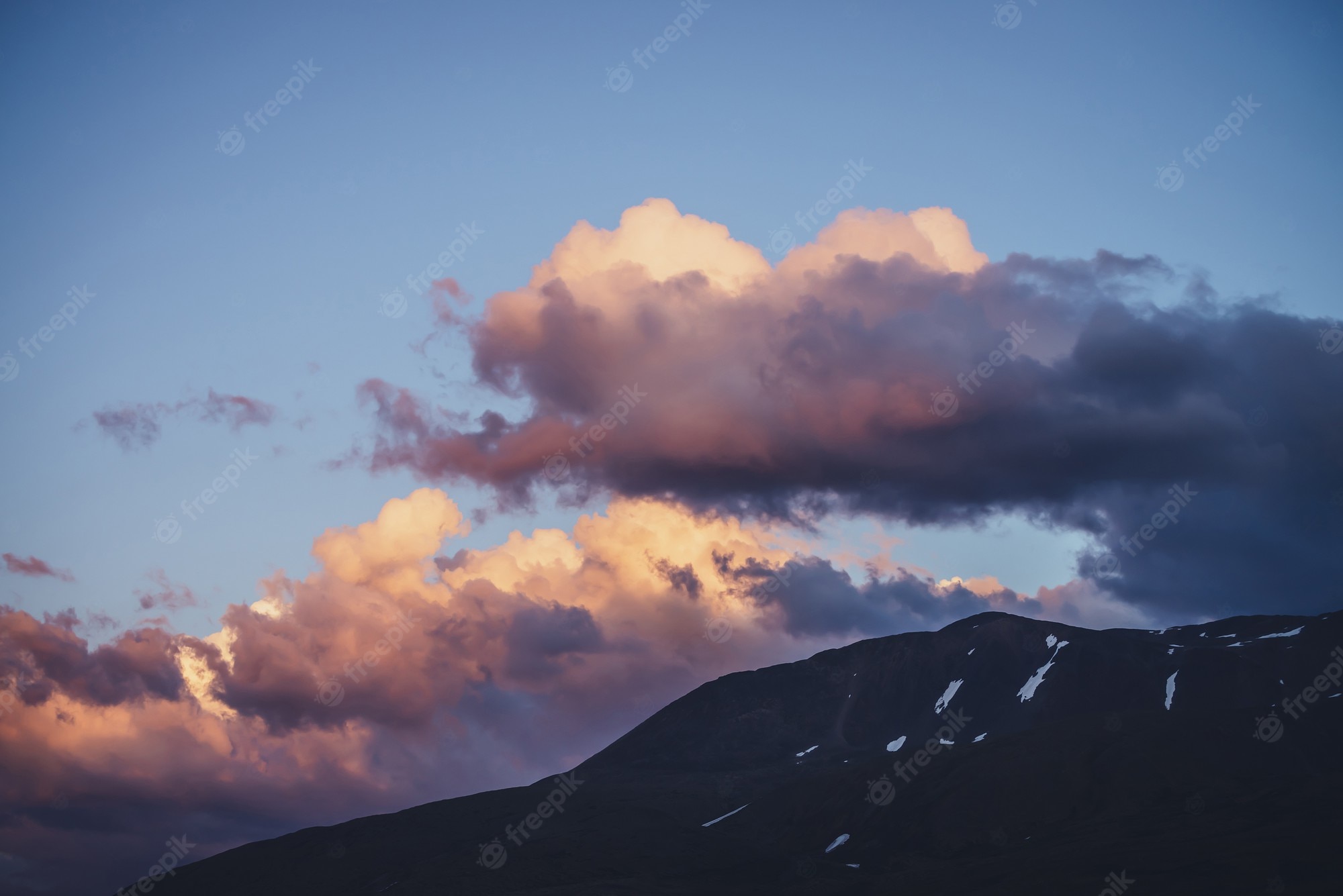 Mountain With Clouds In Background Of Blue And Purple Sky